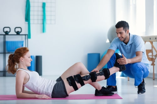 Physical Therapy session where a physical therapist is working on a woman's knee.
