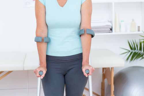 Woman using crutches for physical therapy after orthopedic surgery