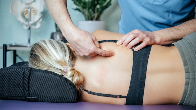 Chiropractic Treatment for Sciatica, a chiropractor helps a woman by offering a spinal adjustment