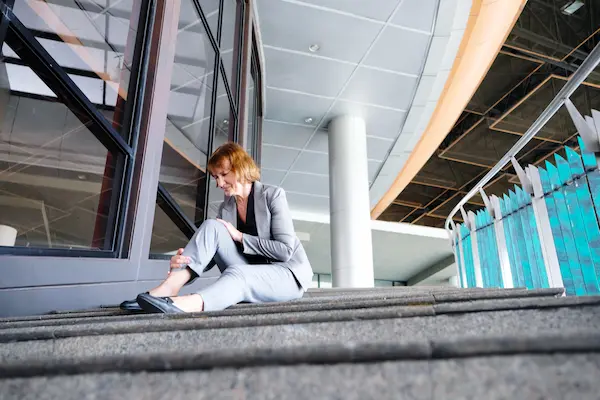 A woman reaches for her leg after a slip-and-fall accident.