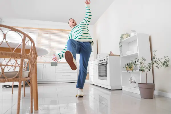 A man starts to fall in his kitchen, and is likely about to become badly injured.