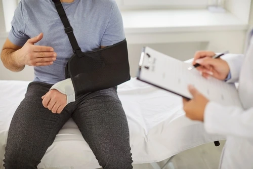 Raleigh workplace injury doctor talking to man with broken arm